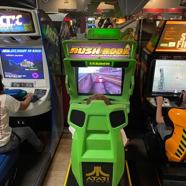 A green driving simulation arcade machine named 'San Francisco Rush Rock'.
